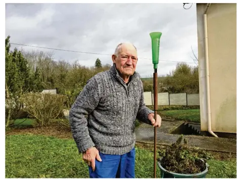  ??  ?? Claude Labarre pose à côté du pluviomètr­e dans son jardin de La Ferté-Gaucher.