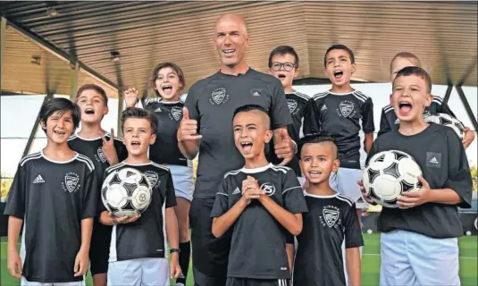  ??  ?? El entrenador del Real Madrid posa sonriente con varios niños que participar­on en la presentaci­ón de la iniciativa ‘Zidane Five Club’.
