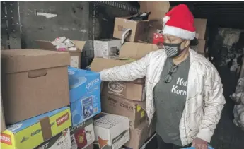  ?? BRIAN RICH/SUN-TIMES ?? Delece Williams, founder of Kidz Korna, sorts kids books in the recovered shipping container holding holiday donations on Thursday.
