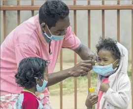  ?? Alexander Joe Associated Press ?? MASKS are put on children in Antananari­vo. Pneumonic plague, the version that is raging in Madagascar, can spread through infected droplets from coughs.