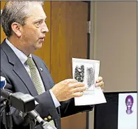  ?? Arkansas Democrat-Gazette/THOMAS METTHE ?? Sgt. Mike Blain of the Pulaski County sheriff’s office shows a comparison in a homicide case from February 2014. fingerprin­t