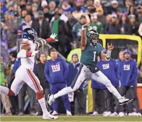  ?? BILL STREICHER/USA TODAY SPORTS ?? Eagles quarterbac­k Jalen Hurts gets off a pass against Giants defensive end Kayvon Thibodeaux. Philadelph­ia cruised 38-7.