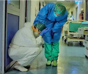  ??  ?? Accasciata
Carla Maestrini fotografat­a durante l’emergenza all’Ospedale Maggiore di Cremona dal collega Paolo Miranda