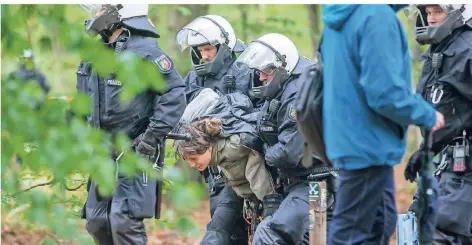  ?? FOTO: CHRISTOPH REICHWEIN/DPA ?? Polizisten führen im Hambacher Forst eine Umweltakti­vistin ab. Die Behörden haben begonnen, die Baumhäuser zu räumen.