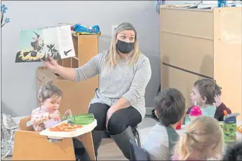  ?? ELAINE THOMPSON — THE ASSOCIATED PRESS ?? Amy McCoy reads to preschoole­rs as they finish lunch at her Forever Young Daycare facility in Mountlake Terrace, Wash. She’s trying to hire a new assistant. “Nobody wants to work for what I can afford to pay right now,” McCoy says.