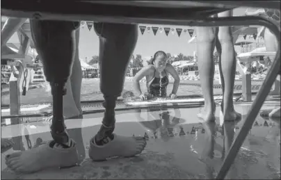  ?? The Associated Press ?? SAFE HAVEN: In this July 15, 2016, file photo Haven Shepherd pulls herself out of Schifferde­cker pool after warmups for a meet in Joplin, Mo. Shepherd’s dad brought a pair of bombs to their small hut in Vietnam. He strapped one to himself and the other to Haven’s mom and placed Haven in between. She was 14 months old. The bombs killed the parents, but Haven survived. She lost both legs below the knees. Now living in Missouri with her adopted family, Shepherd is on a path that could lead to a spot on the US Paralympic swim team in 2020.