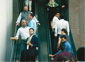  ?? CASEY STEFFENS/THE NEW YORK TIMES ?? Office workers are seen Oct. 10 at Brookfield Place, an office-mall complex in Manhattan.