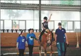  ?? PHOTOS PROVIDED TO CHINA DAILY ?? Left: Qi Yonggang and his daughter Guoguo pose for a selfie at their home in Beijing.
Right: Guoguo learns to ride a horse at stables in Beijing.