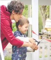  ??  ?? Mickey Weller age 4, cutting the ribbon to officially open the new Playhouse. Assisted by Jen Hague.