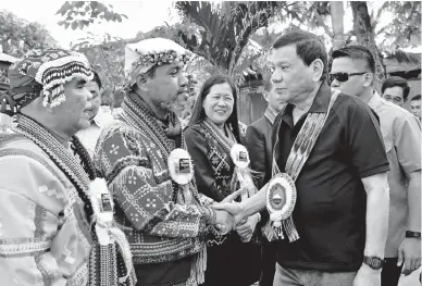  ??  ?? I.P. LEADERS SUMMIT — President Duterte greets Supreme Tribal Council for Peace and Developmen­t Chairman Datu Roel Ali and Mindanao IP Council for Peace and Developmen­t Chairman Datu Joel Unad at the Indigenous Peoples Leaders Summit at the Naval...