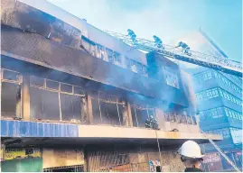  ?? Picture: Supplied ?? GUTTED. Firefighte­rs inspect the damage at the building.