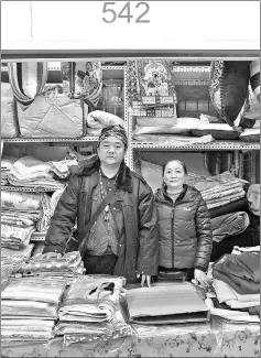  ?? — AFP photos ?? Ge Guoxiang (left) and Jin Hui pose for a portrait at their stall in the Tuanjiehu Tianyu market in Beijing.