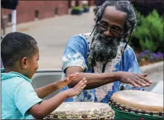  ?? (Democrat-Gazette file photo) ?? Masen Gober, 3, of Benton, has some fun on the djembe, a traditiona­l African drum, with Searcy Ewell during the Africa Day Fest at Bernice Gardens in Little Rock in a 2017 file photo. Ewell returns to Bernice Gardens on Saturdays to lead a Drum Circle. All are welcome and drums are provided.