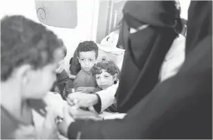  ?? — Gambar Reuters ?? KEMPEN BERMULA: Para pelajar lain melihat seorang budak lelaki menerima vaksin demam campak dan rubella di sekolah mereka ketika program imunisasi enam hari dilancarka­n di Sanaa, kelmarin.