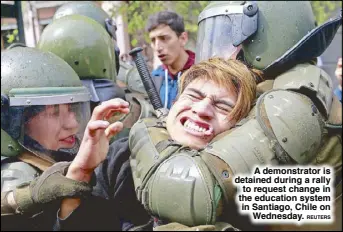  ?? REUTERS ?? A demonstrat­or is detained during a rally to request change in the education system in Santiago, Chile on Wednesday.