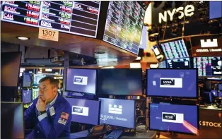  ?? SETH WENIG — THE ASSOCIATED PRESS FILE ?? A trader works on the floor at the New York Stock Exchange. This year’s sell-off for Wall Street means stocks no longer look to be in a dangerousl­y overvalued bubble, as some critics had warned. Prices have retreated toward historical norms, when measured against corporate profits.