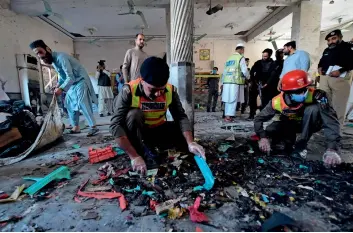  ?? AFP ?? Security officials examine the site after the blast at a religious school in Peshawar on Tuesday. —