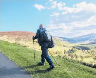  ?? DREAMSTIME ?? A tourist hikes the Irish landscape.