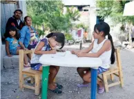  ??  ?? José González no puede pagar los 100 pesos de cuota. Esther recibe clases de su hermana Nicole en el patio de su casa.