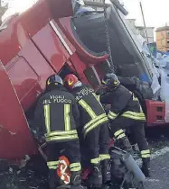  ?? ?? I vigili del fuoco cercano di estrarre il corpo del camionista