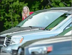  ?? SEAN D. ELLIOT THE DAY ?? Graduate Alexa Pescatello pokes her head out of the car window to look for friends as the Robert E. Fitch High School Class of 2020 gather for their drive-in graduation ceremony Friday in Groton.