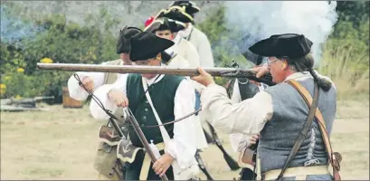  ?? — Photo by Colin Maclean/the Telegram ?? Re-enactors from Fortress Louisbourg in Nova Scotia fire muskets during a demonstrat­ion marking the War of 1812 on Signal Hill Saturday.