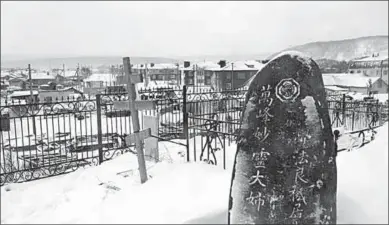  ??  ?? Een Russisch orthodox kruis naast een Japanse graftombe op de Koerilen. (South China Morning Post)
