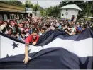  ??  ?? JORGE CABRERA/REUTERS Honduran migrants, part of a caravan trying to reach the US, gesture while arriving to the border between Honduras and Guatemala, in Agua Caliente, Guatemala, on October 15, 2018.