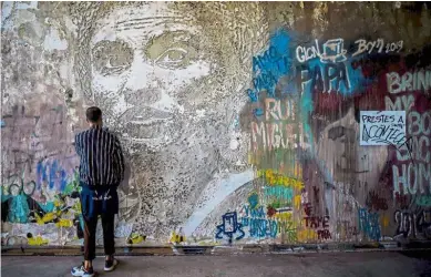  ?? — AFP ?? In loving memory: A man standing in front of an artwork in memory of Franco by Portuguese artist Vhils at the Monsanto panoramic viewpoint in Lisbon, Portugal.