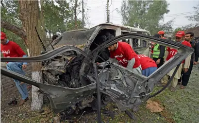  ?? AFP ?? Volunteers search for victims in the destroyed van after the suicide bomb attack in Peshawar on Wednesday. —