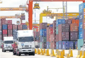  ?? APICHART JINAKUL ?? Cranes work to load cargo containers at the Laem Chabang port.