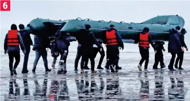  ?? ?? Members of the group, only a few wearing red life jackets, head towards the waves