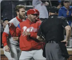  ?? FRANK FRANKLIN II - THE ASSOCIATED PRESS FILE ?? Phillies manager Gabe Kapler, center between Bryce Harper and an umpire in this entertaini­ng snapshot from the season, has successful­ly stemmed the tide of management blowback during this sinking season of too many poor performanc­es and too much bad injury luck. The future remains speculativ­e.