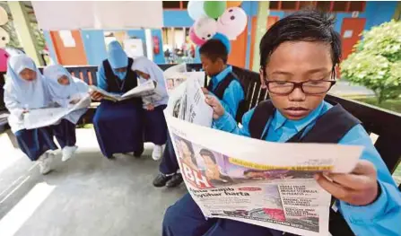  ??  ?? Murid SK Ladang Pendas berehat di wakaf sambil membaca akhbar BH.