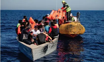  ?? Photograph: Camille Martin Juan/Sos Mediterran­ee/Reuters ?? Crew members of an NGO rescue ship give lifejacket­s to refugees on an overcrowde­d boat in the Mediterran­ean in October.