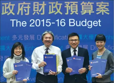  ?? ROY LIU / CHINA DAILY ?? Financial Secretary John Tsang Chun-wah (second left), Secretary for Financial Services and the Treasury Ceajer Chan Ka-keung (second right) and their colleagues display booklets of the 2015-16 Budget during a press conference at Central Government Offices in Tamar on Wednesday.