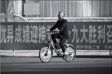  ??  ?? A man rides a sharing bicycle past a promotiona­l billboard for the 19th National Congress of the Communist Party of China in Beijing on Wednesday. The week-long, twice-a-decade congress will be held on October 18.