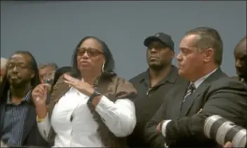  ??  ?? Tre Lane’s mother Regina Jenkins, center, speaks to the hundreds of people who gathered at the Trenton Police Department to call for community action. With her are, from left, Tre Lane’s stepfather, John Jenkins, Tre’s father, William Lane (wearing...