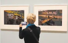  ?? Eric Risberg / AP 2018 ?? A visitor frames up a picture of photos by Paul Fusco that made up the 2018 “The Train: RFK’s Last Journey” exhibit at the San Francisco Museum of Modern Art.