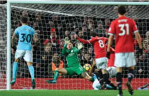  ??  ?? Manchester City’s Ederson makes the second of a double save from Manchester United’s Juan Mata