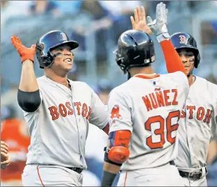  ?? Paul J. Bereswill ?? HIGH ‘FIVE’: Rafael Devers accepts congratula­tions from Red Sox teammate Eduardo Nunez after opening a 5-for-5 game with a grand slam Saturday.