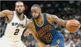  ??  ?? Pushing on: Cleveland Cavaliers’ LeBron James (right) tries to get past San Antonio Spurs’ Kawhi Leonard in the NBA game in San Antonio on Monday.