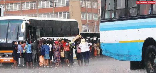  ?? Pic: Shepherd Tozvireva ?? Commuters get drenched in rain as they shove to find transport home at Market Square bus terminus in Harare on Monday. The afternoon rains caught many unawares.