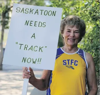  ?? MICHELLE BERG ?? Former Saskatoon Olympian Margaret Tosh holds a sign outside city hall, demonstrat­ing in favour of a new track. Griffiths Stadium will lose its track next year and get artificial turf for football instead.