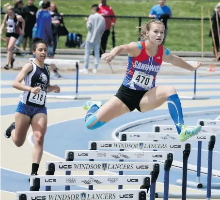  ?? NICK BRANCACCIO ?? Karlie Moore, right, of Sandwich Secondary School leads Jerriah Kelly of Holy Names during the WECSSAA women’s hurdles event at University of Windsor Stadium on Tuesday. Moore finished first with a time of 1:05.34, while Kelly placed third.