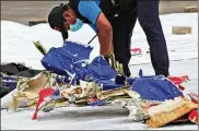  ?? AP ?? An investigat­or of Indonesian­NationalTr­ansportati­on SafetyComm­ittee inspects parts ofSriwijay­a Air Flight 182 at TanjungPri­okPort in Jakarta onSunday. Indonesian rescuers pulled out body parts, pieces of clothing and scraps ofmetal fromthe Java Sea early Sunday.