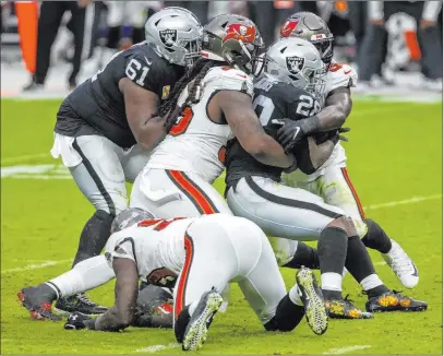  ?? Heidi Fang Las Vegas Review-journal @Heidi Fang ?? Center Rodney Hudson, left, tries to assist as running back Josh Jacobs is tackled for a loss by Tampa’s defense.