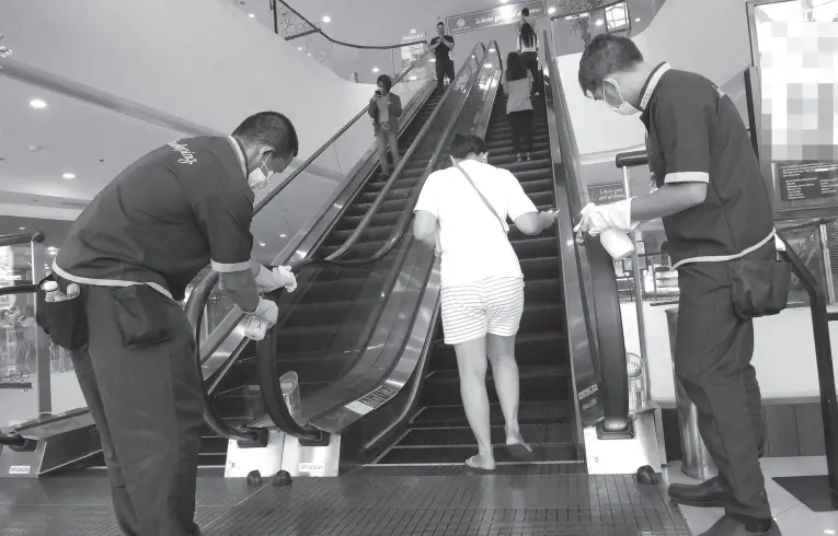  ?? (PNA photo by Robert Oswald P. Alfiler) ?? DISINFECTI­ON. Sanitation team members constantly clean the escalator to keep it germ-free on Friday (March 13) at Fisher Mall in Quezon City. The Department of Health has advised all establishm­ents in the country to maintain cleanlines­s to prevent the further spread of COVID-19.