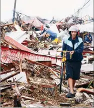  ?? Noel Celis/Getty Images ?? A man walks past debris of destroyed houses on Sunday in Tacloban, eastern island of Leyte. The Pentagon said it is providing the Philippine­s with naval and aviation resources in the wake of a devastatin­g typhoon.