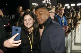  ?? PHOTO BY CHRIS PIZZELLO — INVISION — AP ?? In this Dec. 9, 2017photo, “Star Wars: The Last Jedi” cast member John Boyega, right, poses for photo with Olivia Sava, 14, of New York, at the premiere of the film at the Shrine Auditorium in Los Angeles. Sava was one of seven teens with...